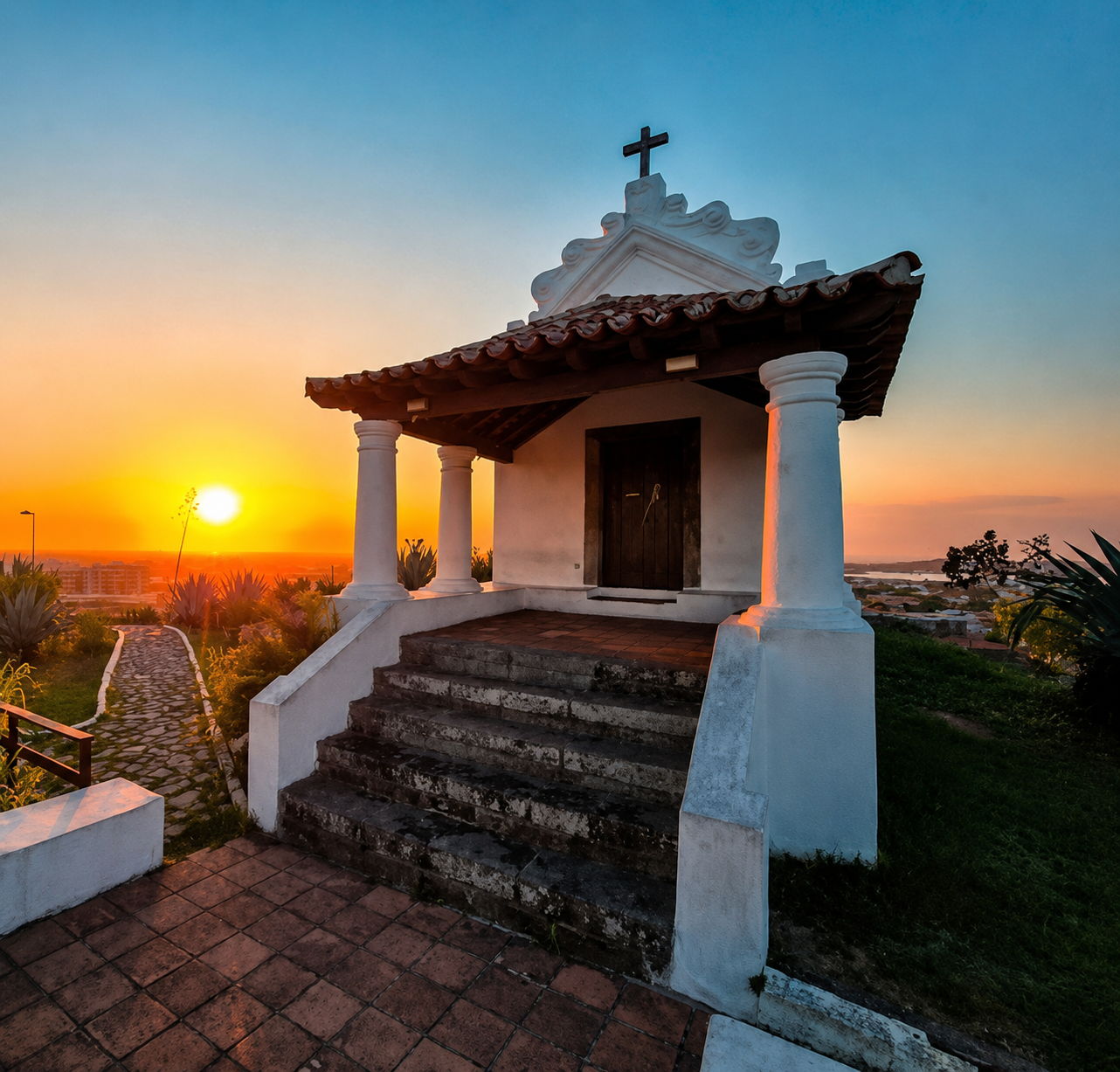 Capela do Morro da Guia no pôr do sol, com o sol baixo no horizonte