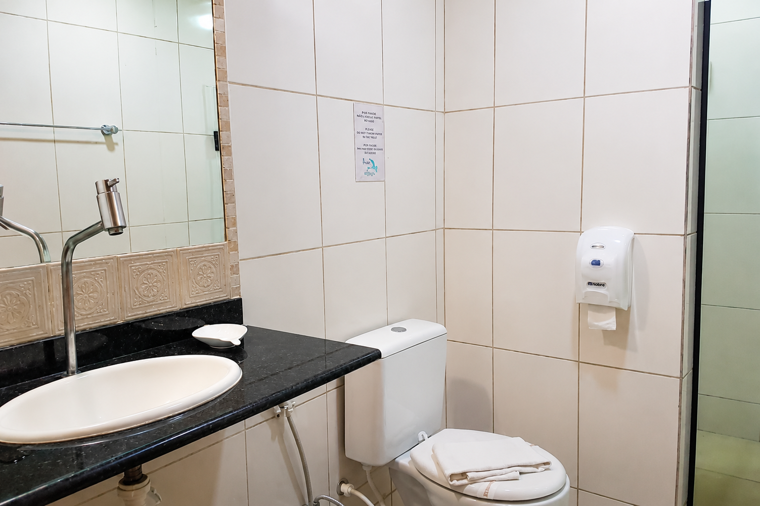Banheiro com pia, espelho e vaso sanitário