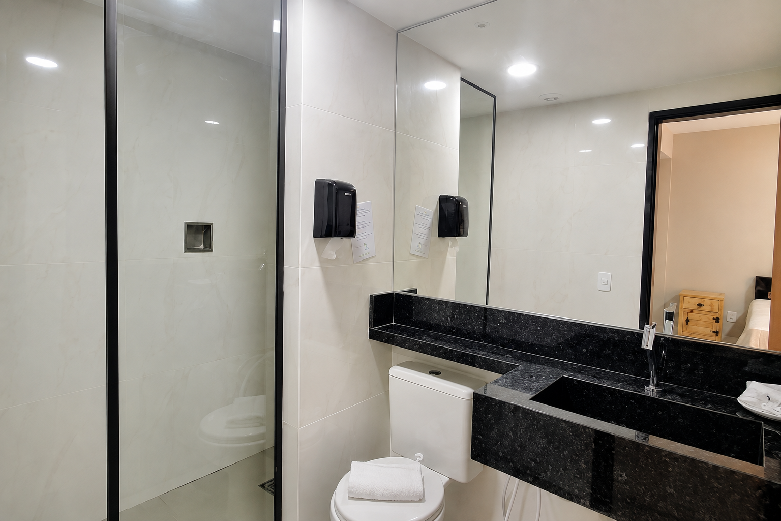 Banheiro da Suíte Deluxe com box de vidro e bancada de granito