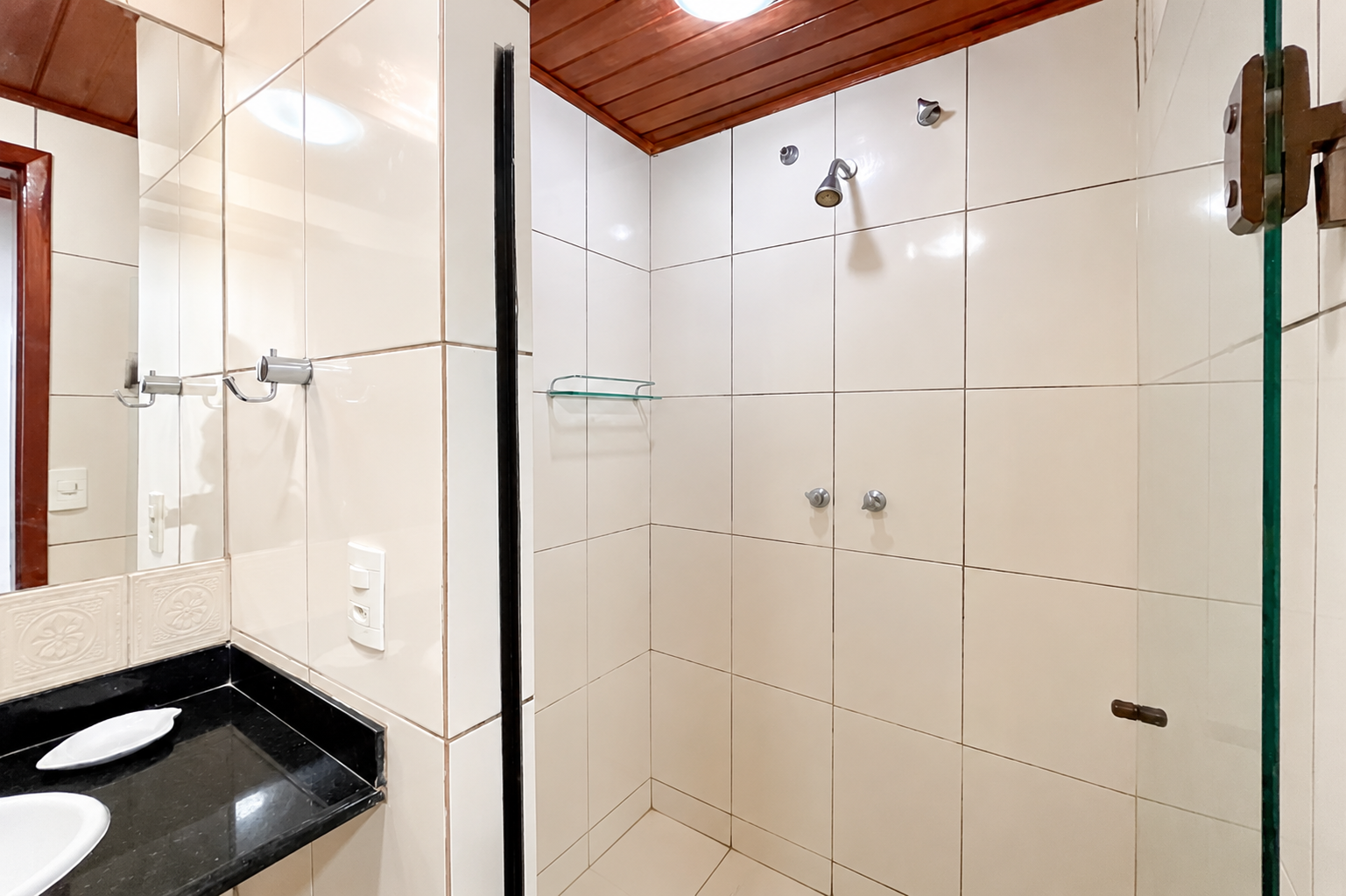 Banheiro com box de vidro e bancada de granito