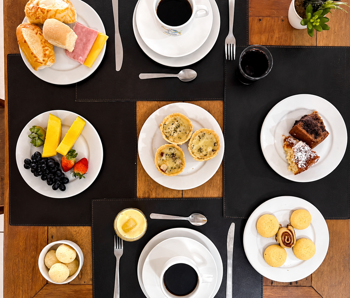 Mesa posta vista de cima com café e salgados